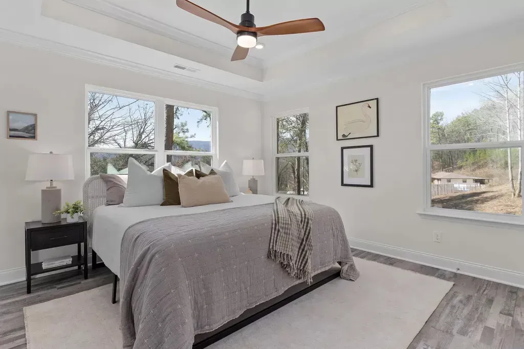 A bedroom with a large bed and a ceiling fan.