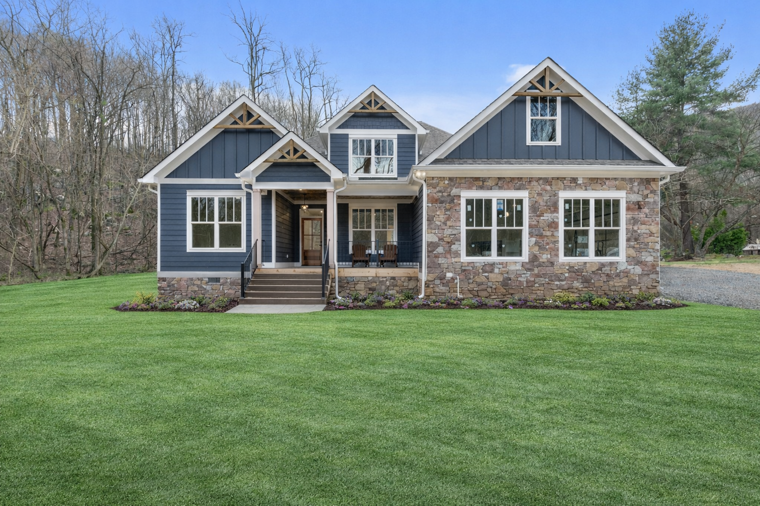A large house with a lot of windows is sitting on top of a dirt field.