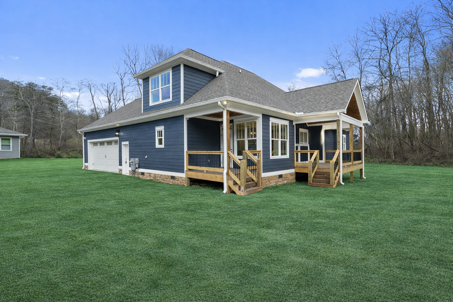 A large house is sitting in the middle of a dirt field.