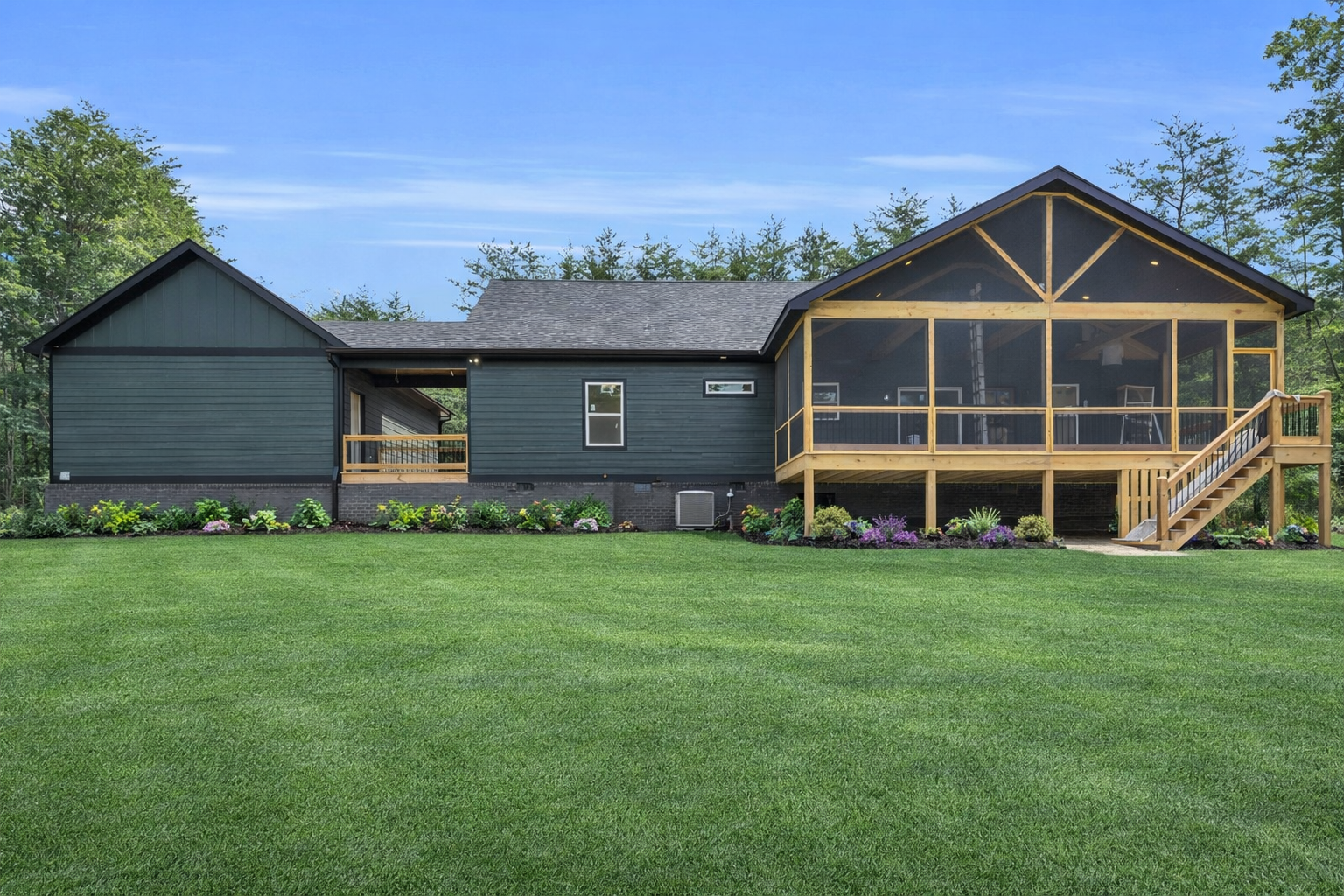 Blue house with screened porch and wooden deck under construction.
