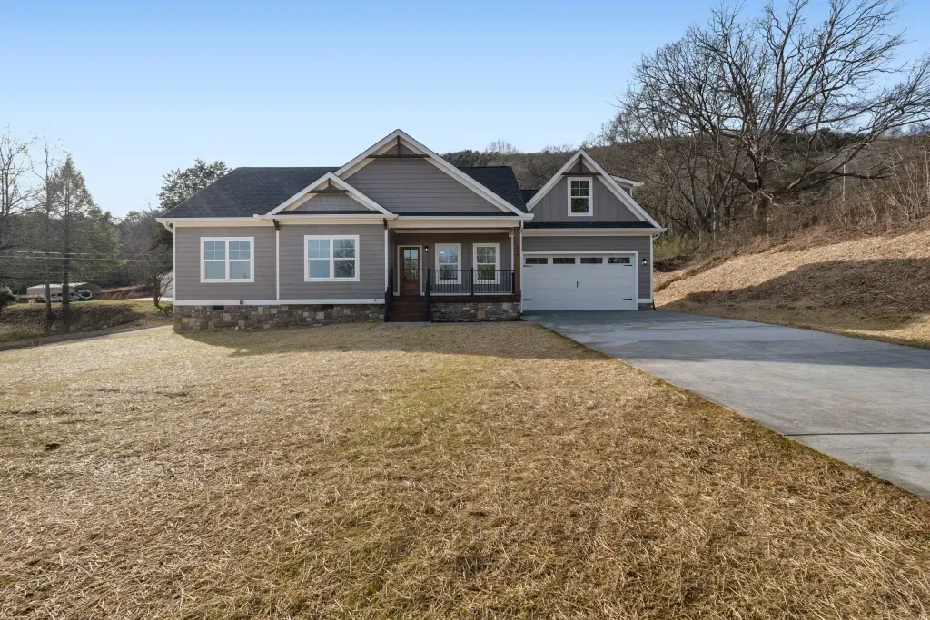 A house with a garage and a driveway in front of it.