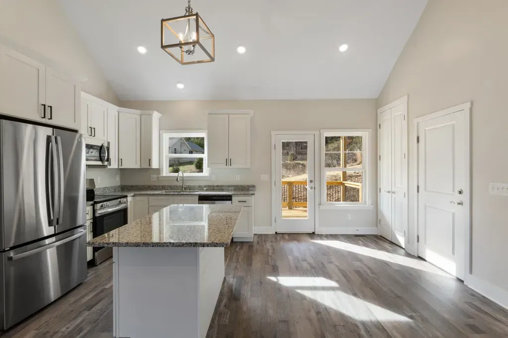 An empty kitchen with stainless steel appliances and granite counter tops.