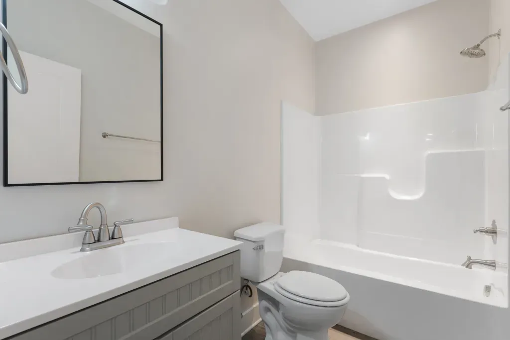 A bathroom with a toilet , sink , and bathtub.