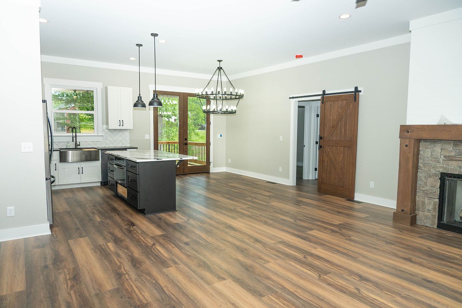 Open-concept kitchen and living space with dark wood floors, a kitchen island, and a fireplace.