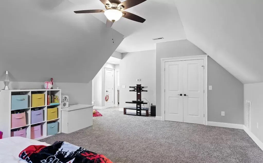 A bedroom with a ceiling fan and a bed.