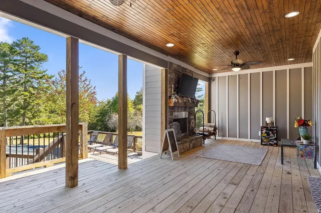 A large wooden deck with a fireplace and television on it.
