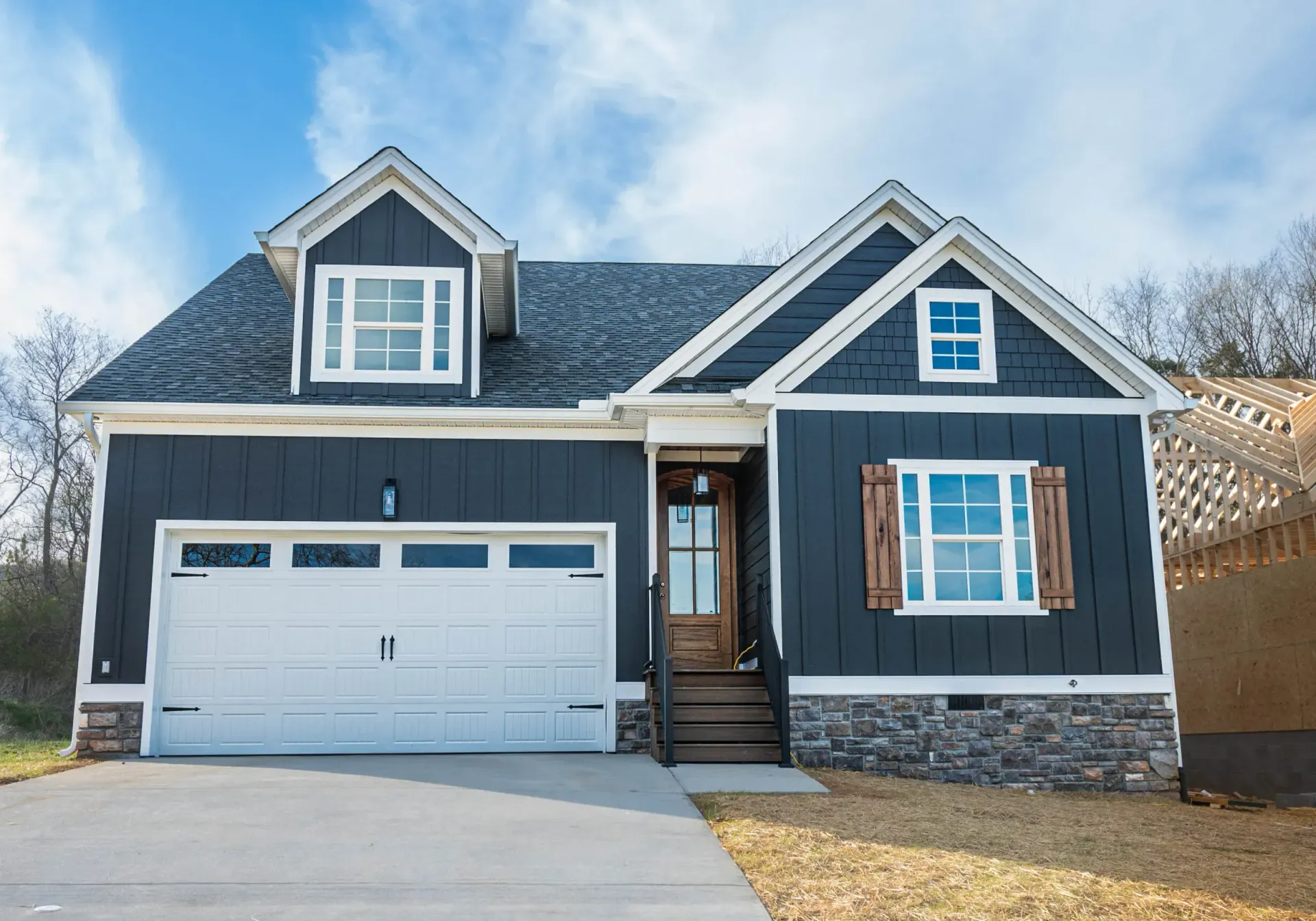 A large house with a blue siding and a white garage door.
