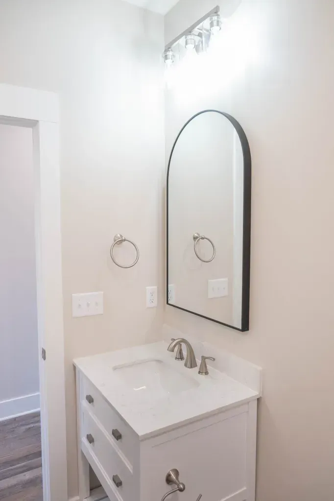 A bathroom with a sink and a mirror on the wall.