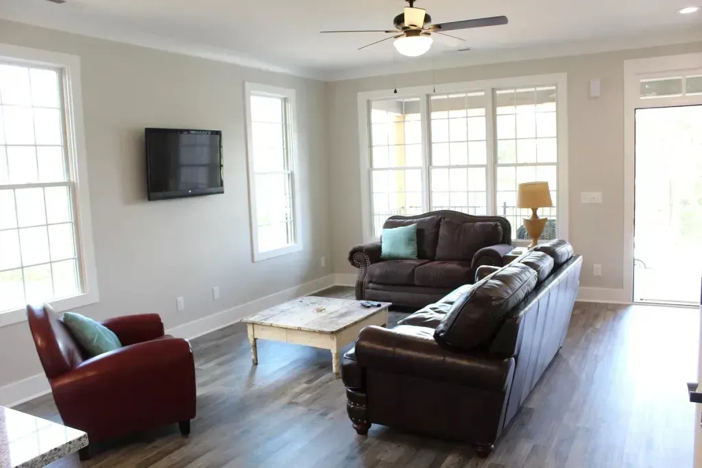 A living room with a couch , chairs , coffee table and television.