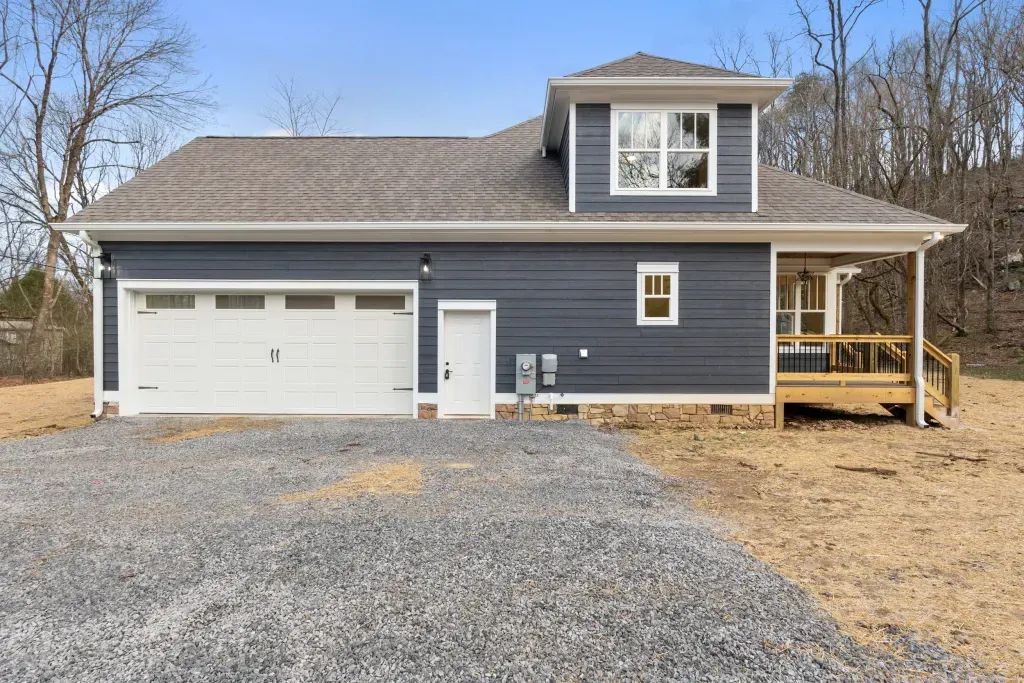 A blue house with a white garage door and a porch.