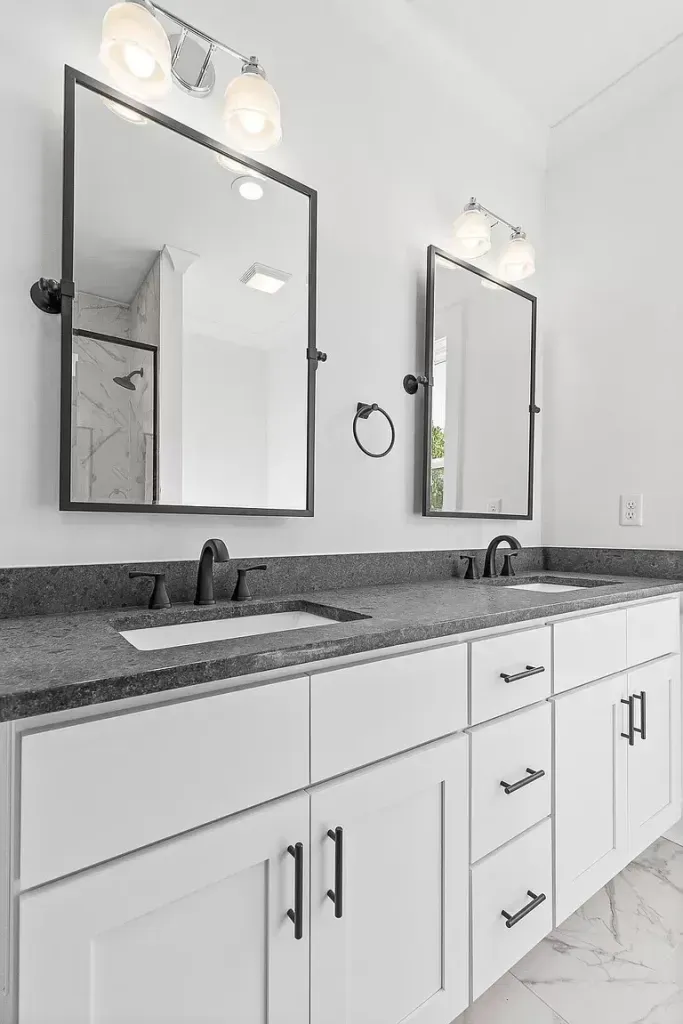 A bathroom with two sinks and two mirrors.