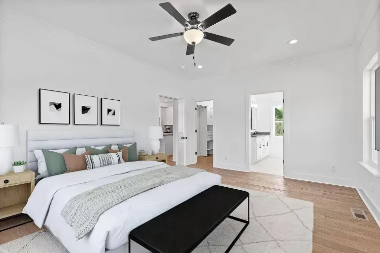 A bedroom with a large bed and a ceiling fan.