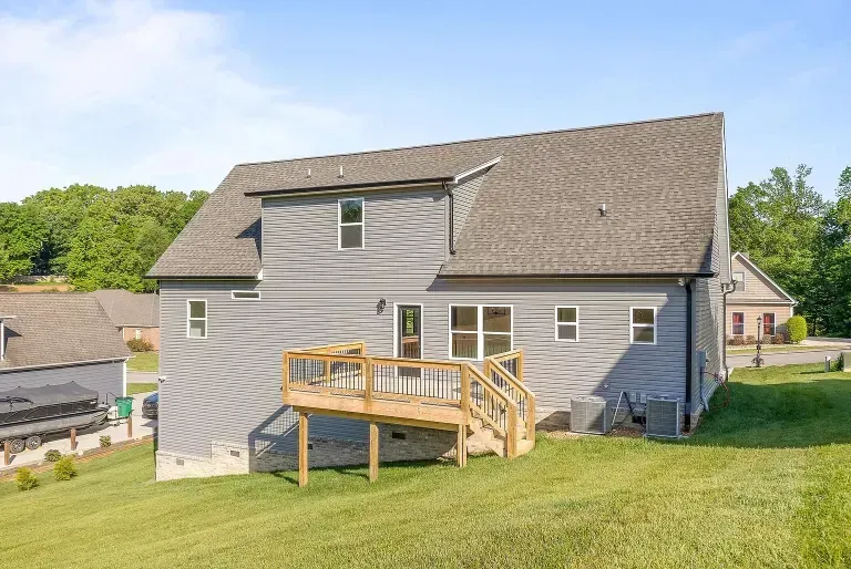 The back of a house with a large deck and stairs.