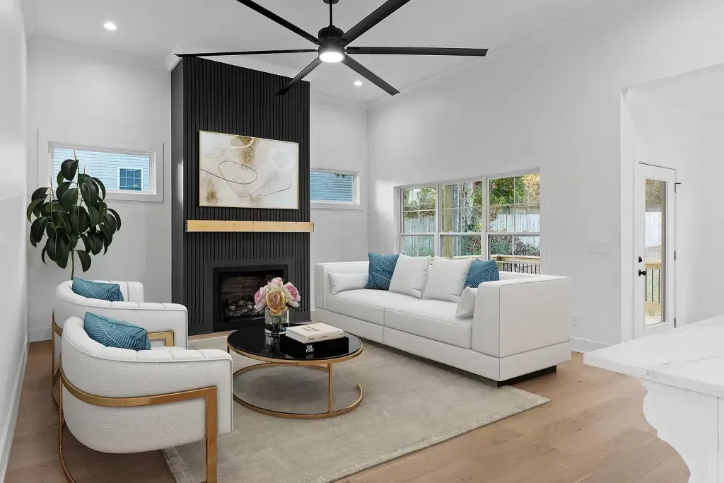 A living room with a couch , chairs , coffee table and ceiling fan.