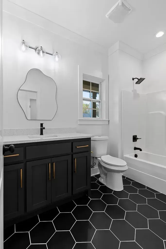 A bathroom with a toilet , sink , mirror and bathtub.