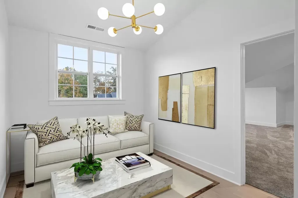 A living room with a couch , coffee table , and paintings on the wall.