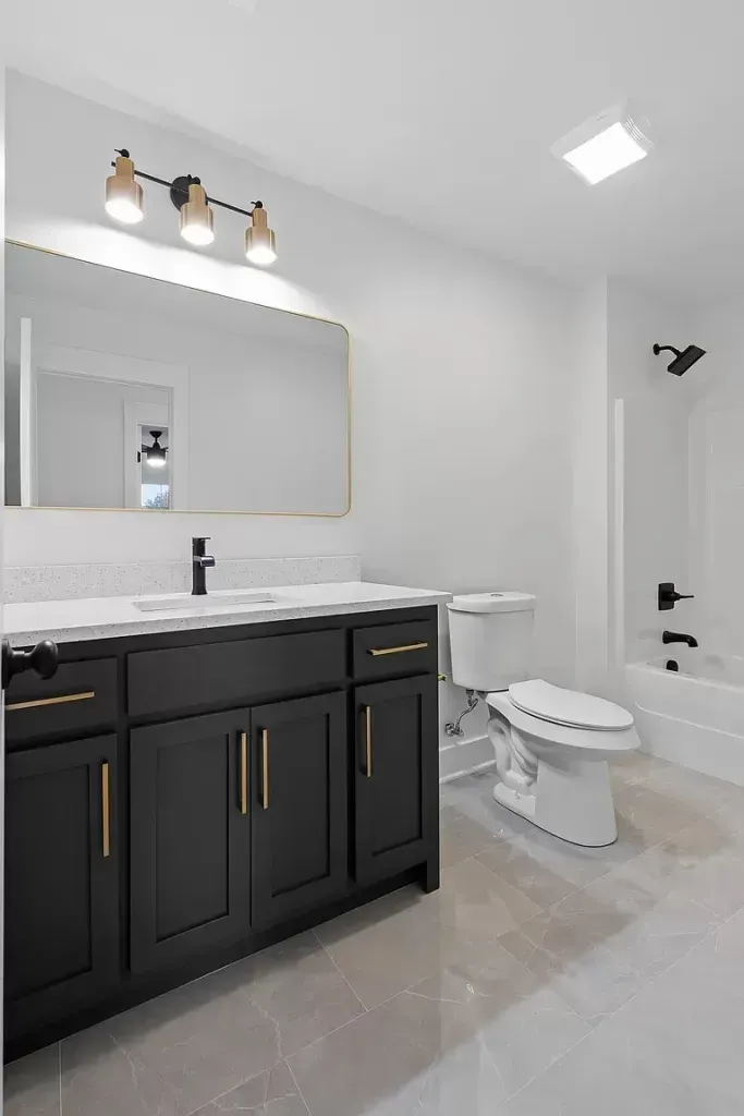 A bathroom with a toilet , sink , mirror and bathtub.
