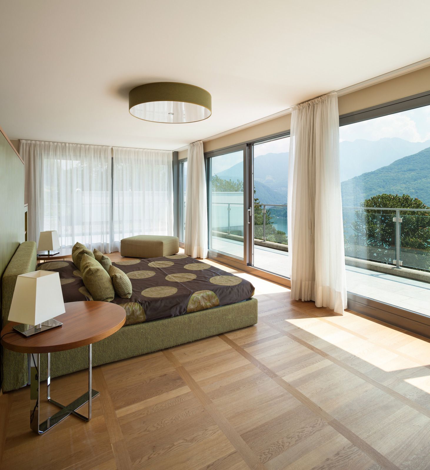 Bedroom with dark wood bed, light gray walls, tray ceiling, and blue curtains.