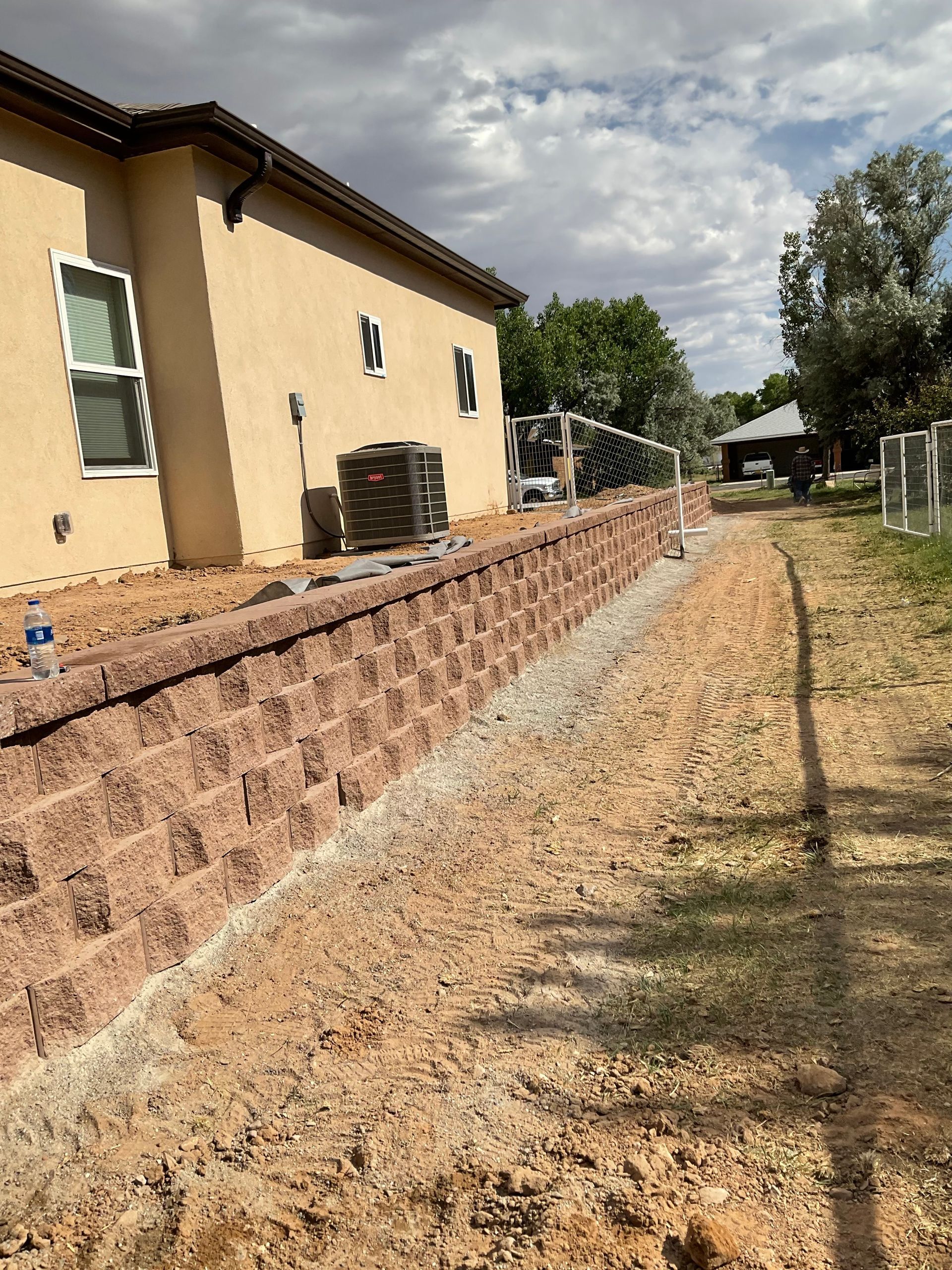 A brick wall is being built in front of a house.