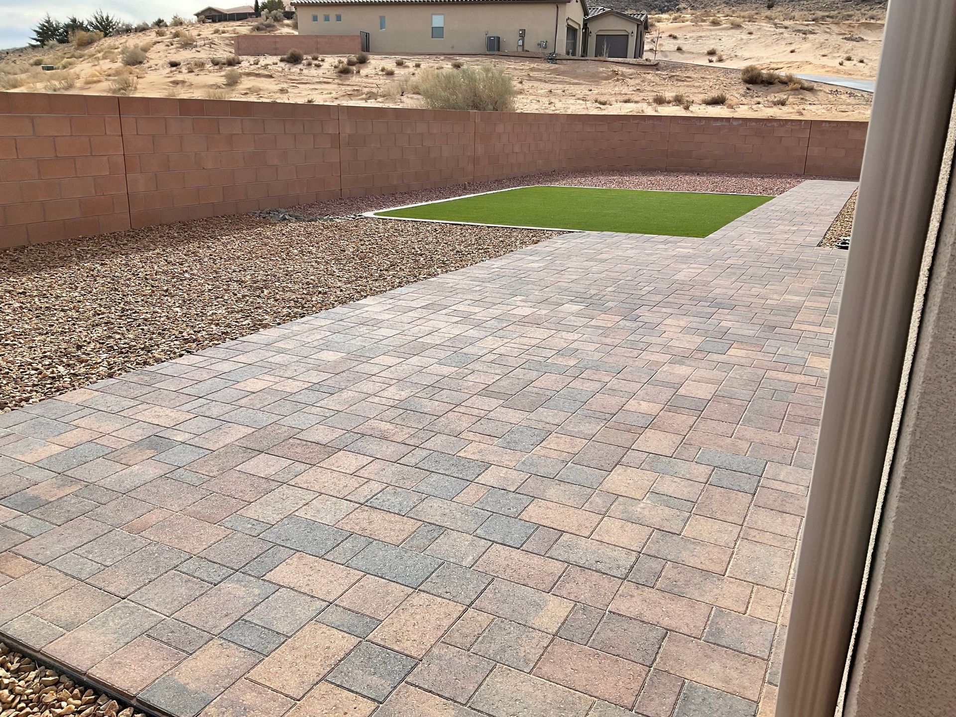 A brick walkway leading to a house in the desert