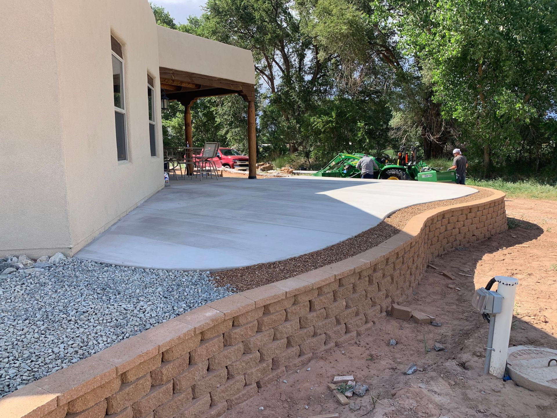 A concrete patio is being built in front of a house.