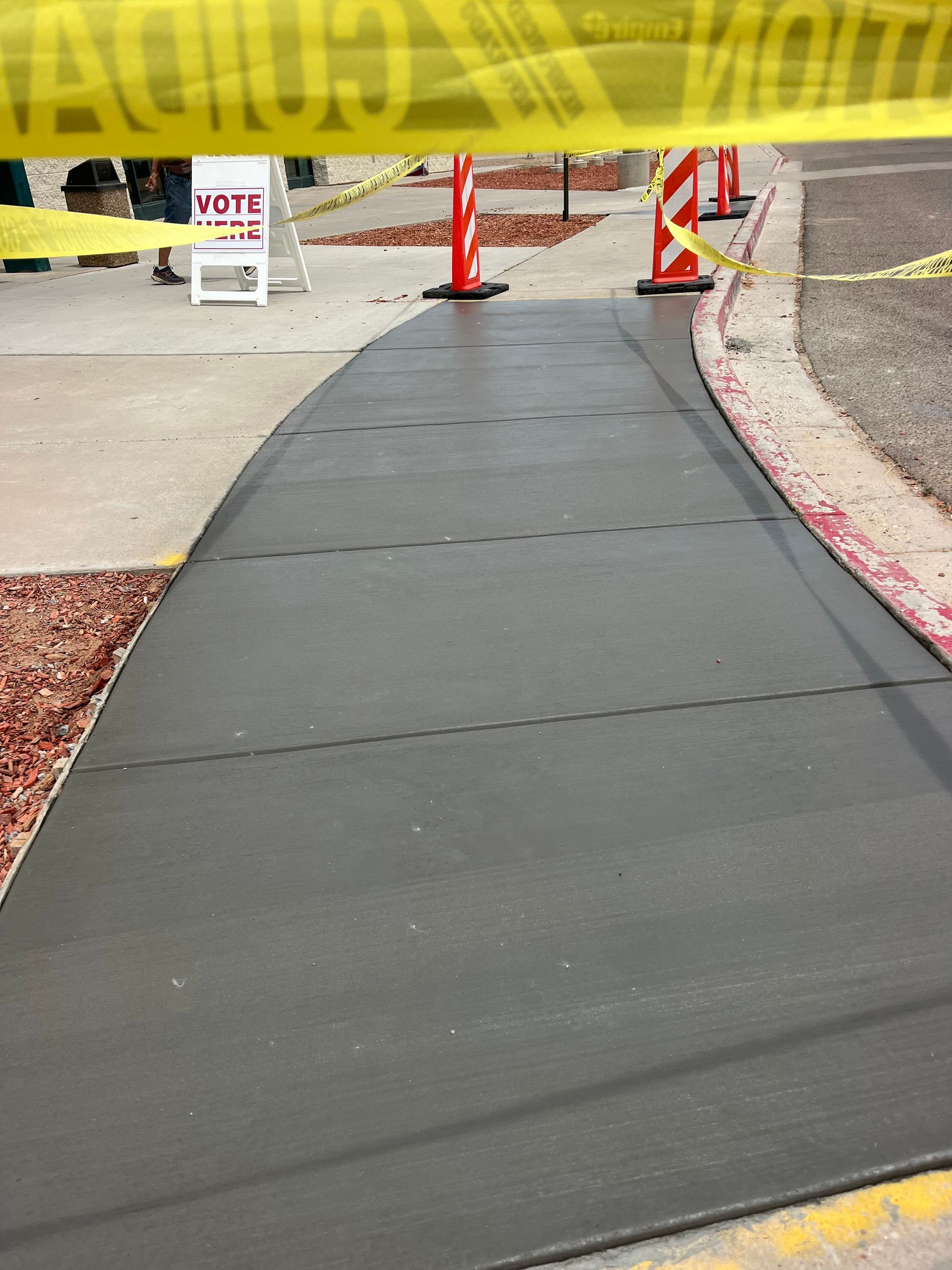 A sidewalk with a sign that says vote on it