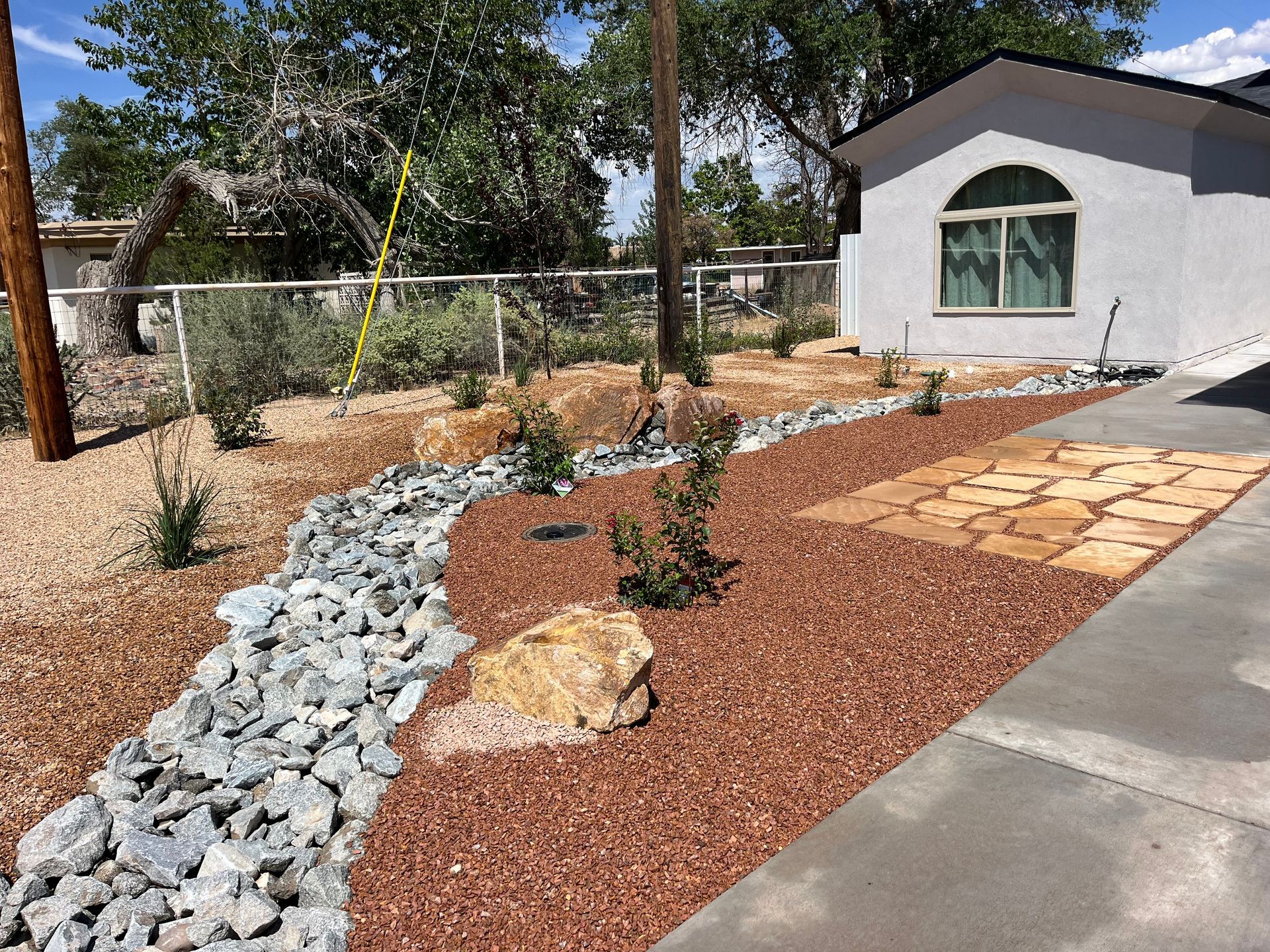 A house with a walkway leading to it surrounded by rocks and gravel.