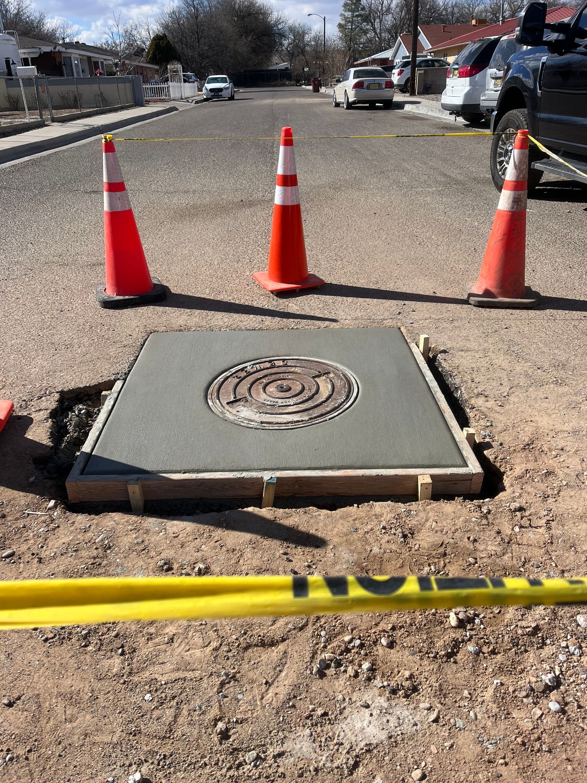 A manhole cover is being installed on the side of the road.
