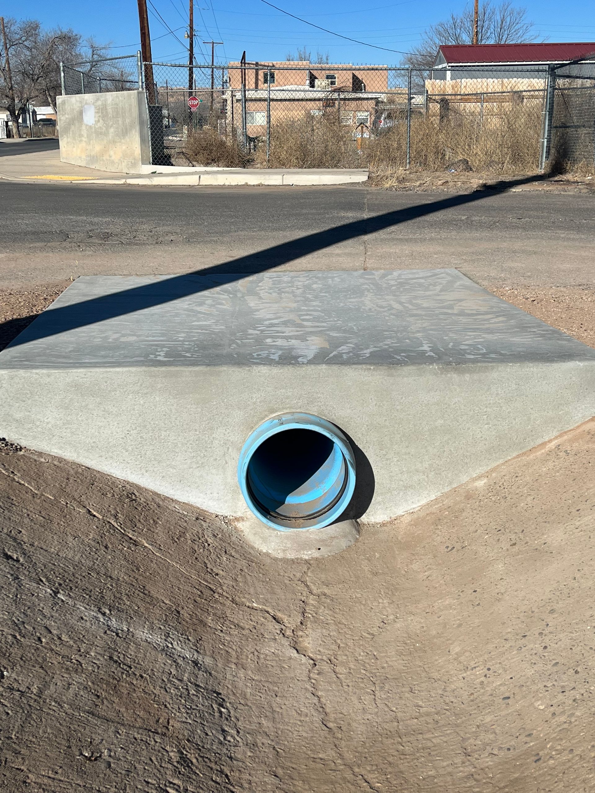 A blue pipe is sitting on the side of a road.