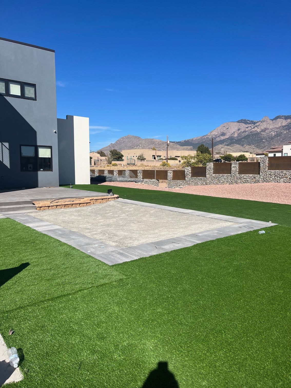 A large lawn with a building in the background and mountains in the background