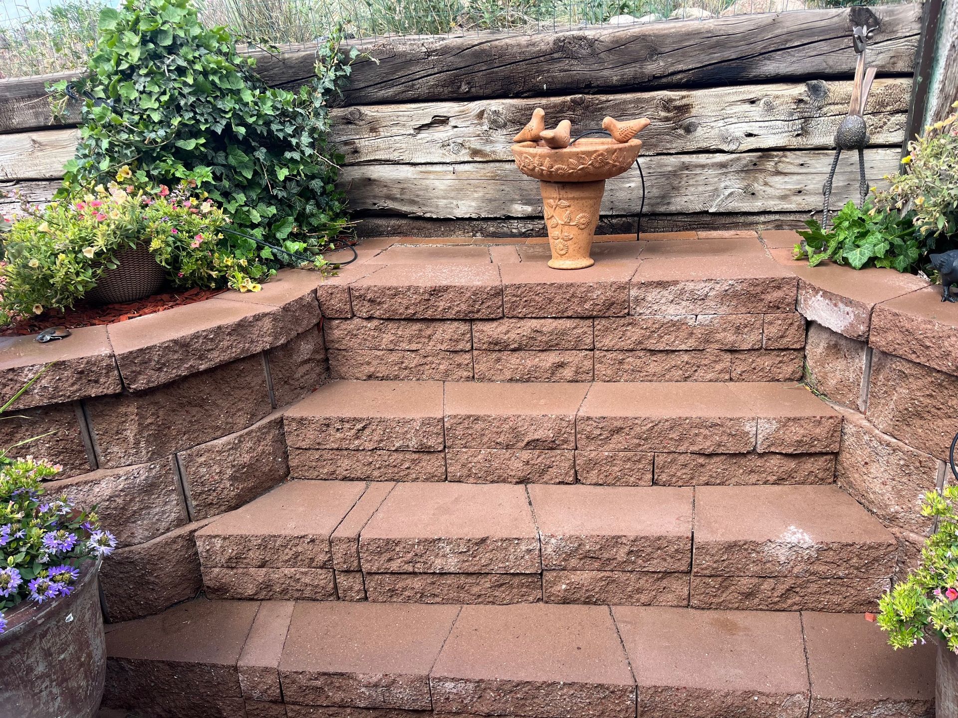 A bird bath is sitting on top of a set of stairs.