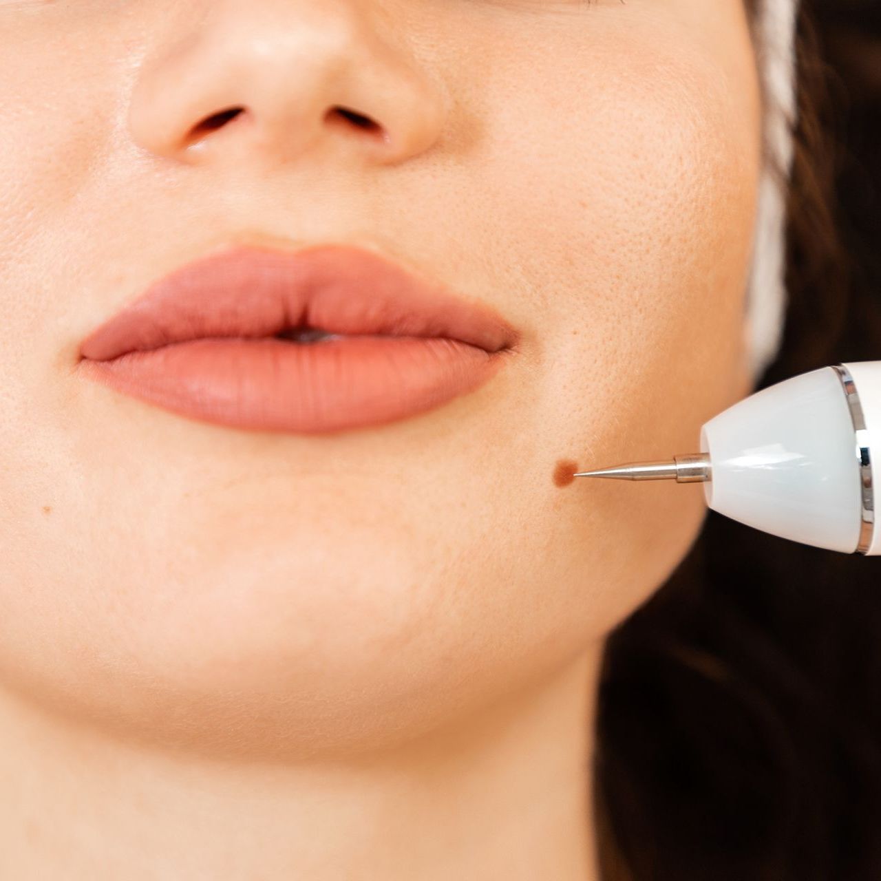 A close up of a woman 's face with a needle in it