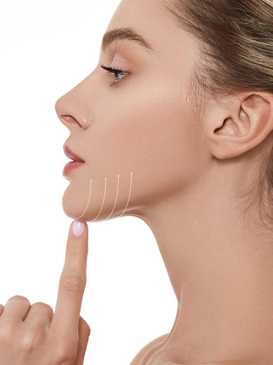 A woman is smiling with her hand on her chin.