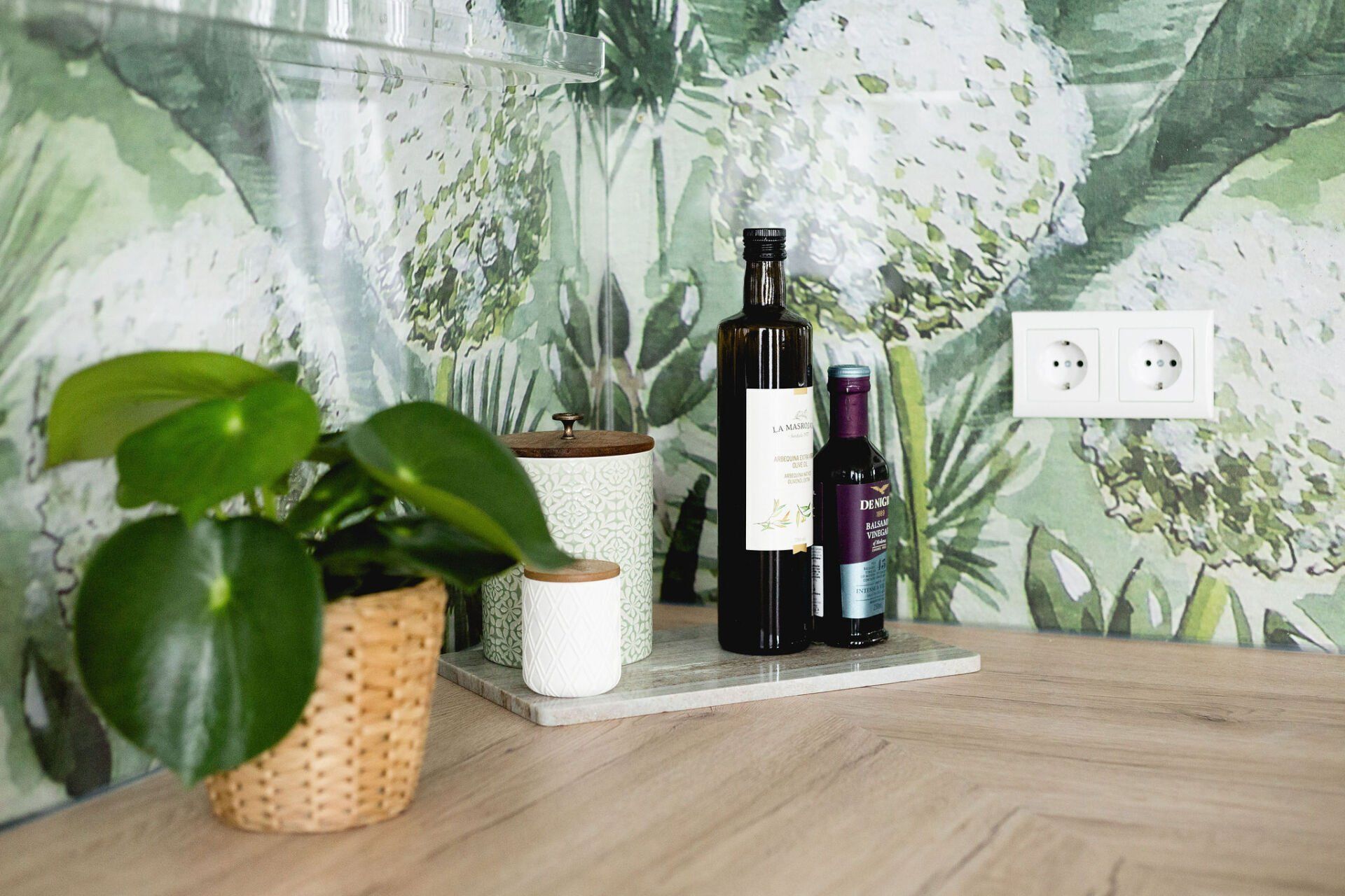 Eine Flasche Wein und eine Topfpflanze stehen auf einem Holztisch.