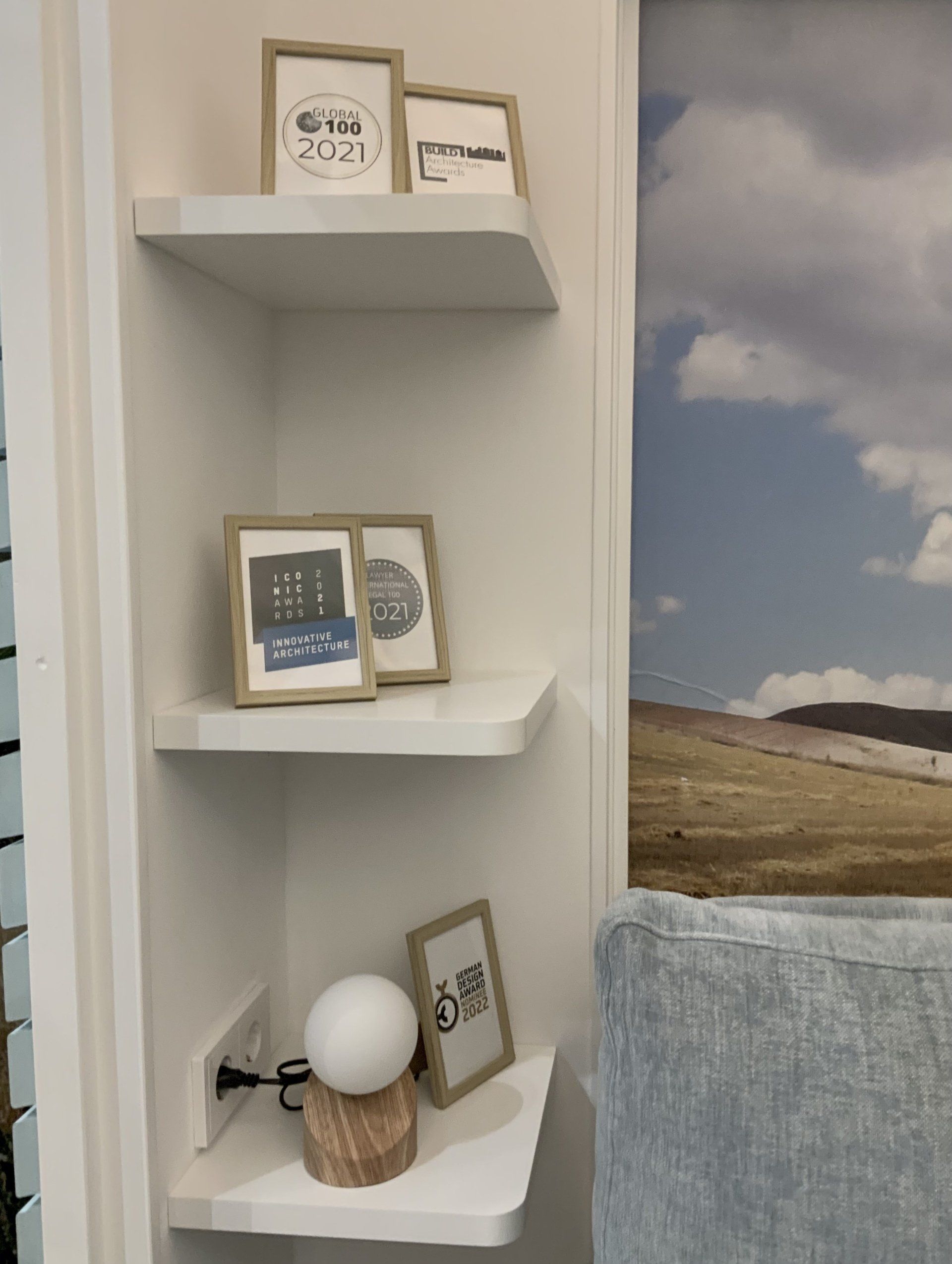 Eine Ecke einer Wand mit Regalen und einem Bild darauf