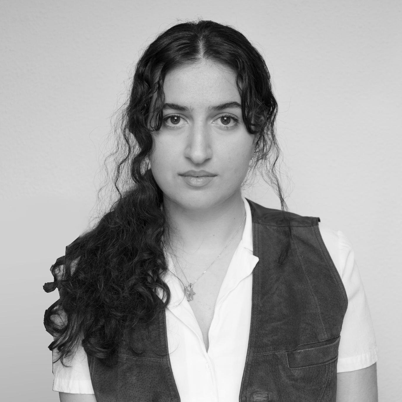 Ein Schwarzweißfoto einer Frau, die eine Weste und ein weißes Hemd trägt