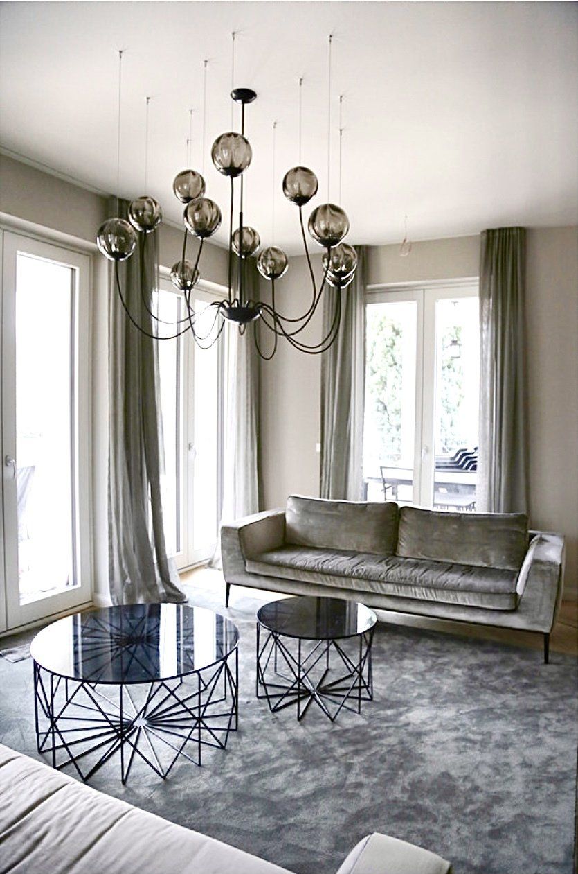 Ein Wohnzimmer mit einer Couch, zwei Couchtischen und einem Kronleuchter.