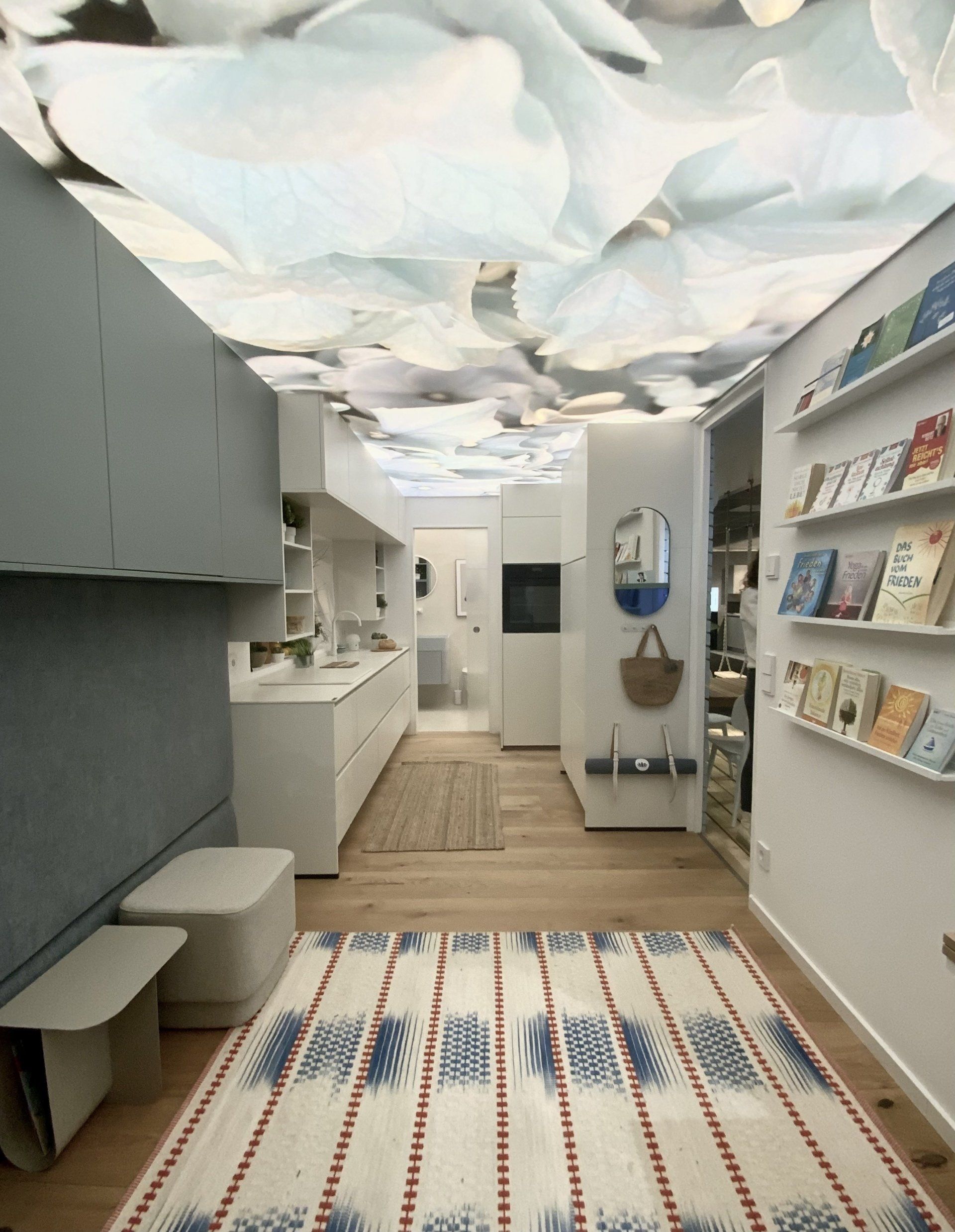 Ein Flur mit einem Teppich auf dem Boden und einer Decke mit Blumen daran