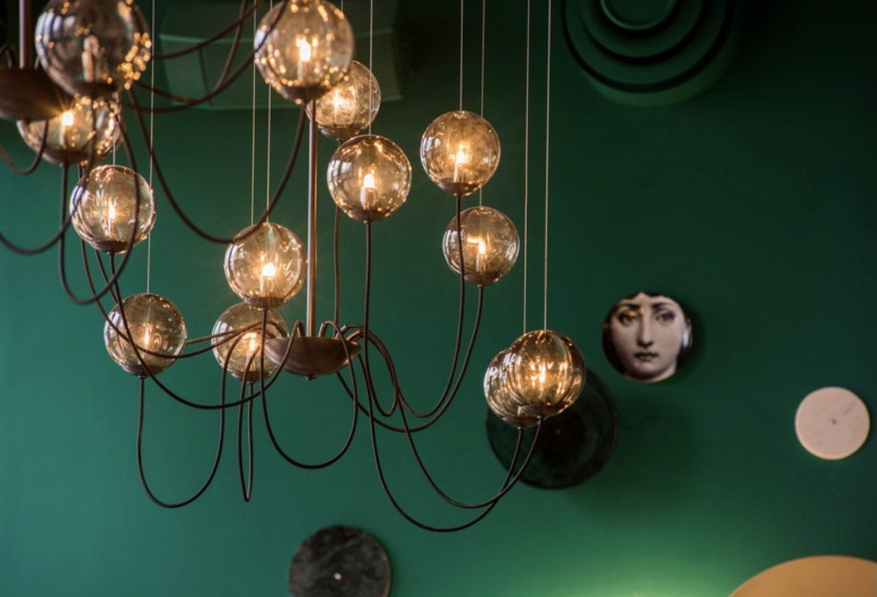 In einem Raum mit einer grünen Wand hängt ein Kronleuchter von der Decke.