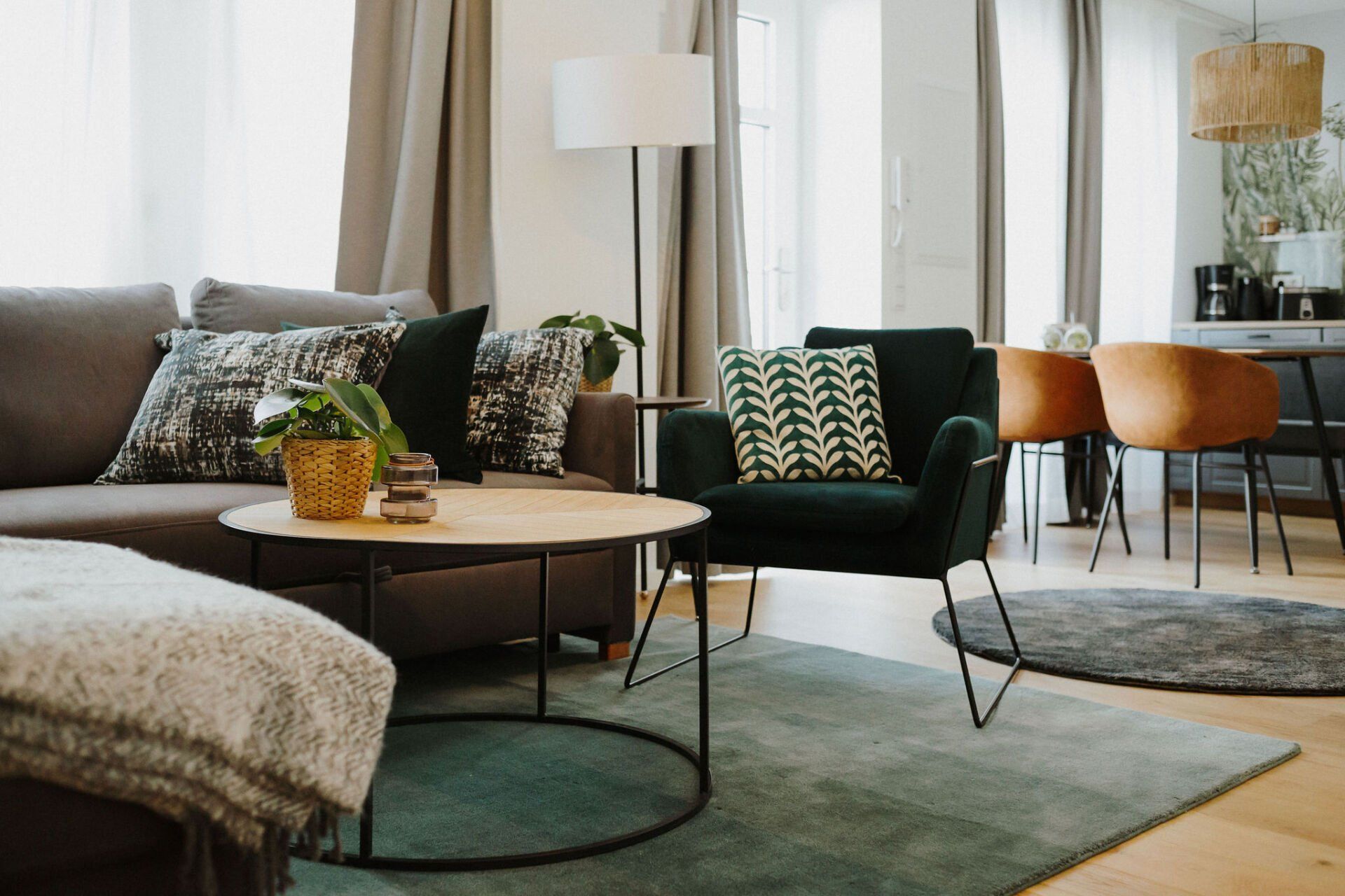 Ein Wohnzimmer mit Couch, Sessel, Couchtisch und Teppich.