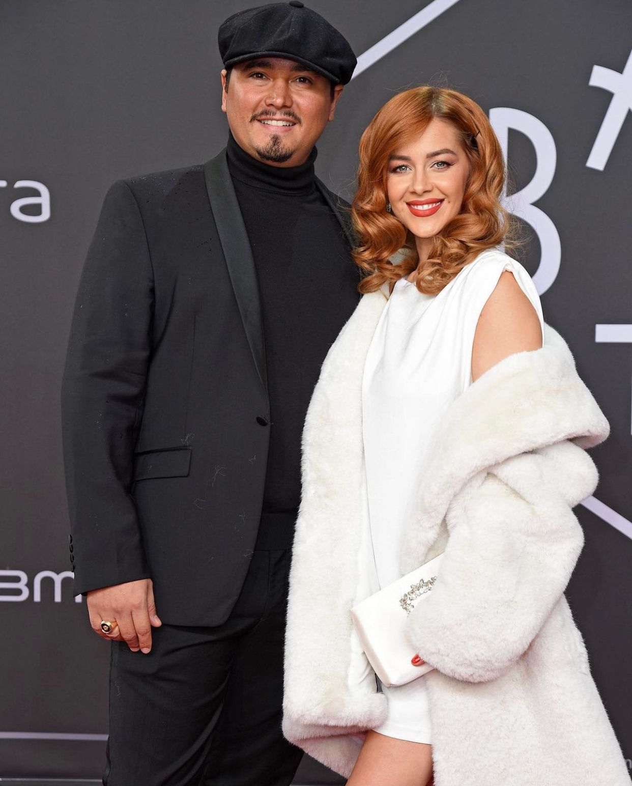 Ein Mann und eine Frau stehen nebeneinander auf einem roten Teppich.