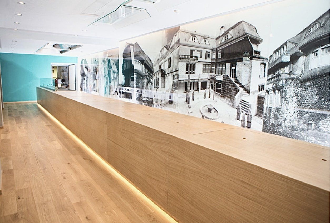 Eine lange Holztheke mit einem Bild an der Wand dahinter.