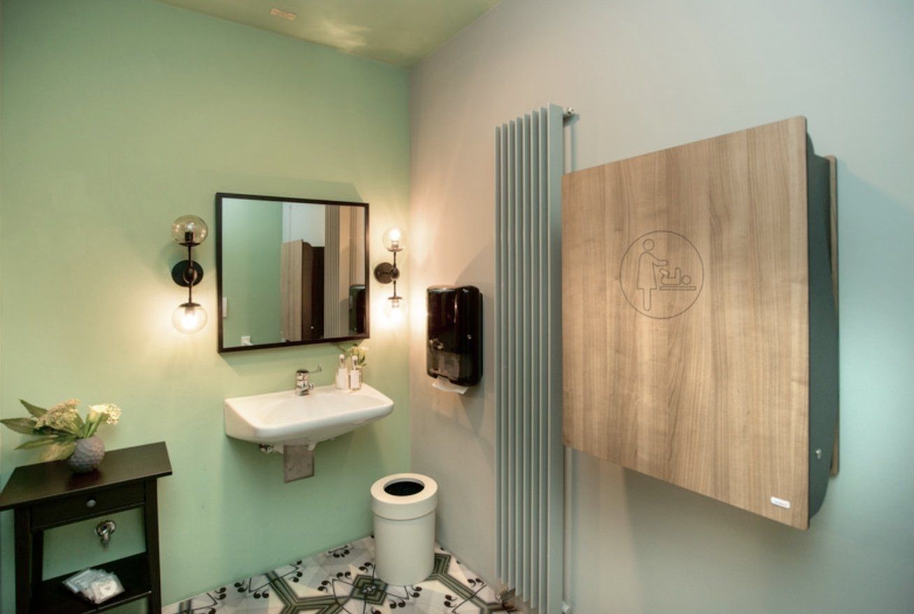 Ein Badezimmer mit Waschbecken, Toilette, Spiegel und Heizkörper.