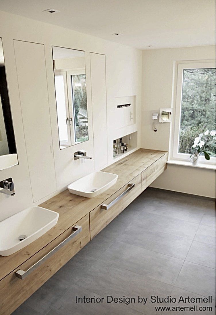 Ein Badezimmer mit zwei Waschbecken, einem Spiegel und einem Fenster.