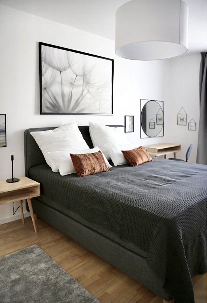 Ein Schlafzimmer mit einem großen Bett und einem Bild an der Wand darüber.