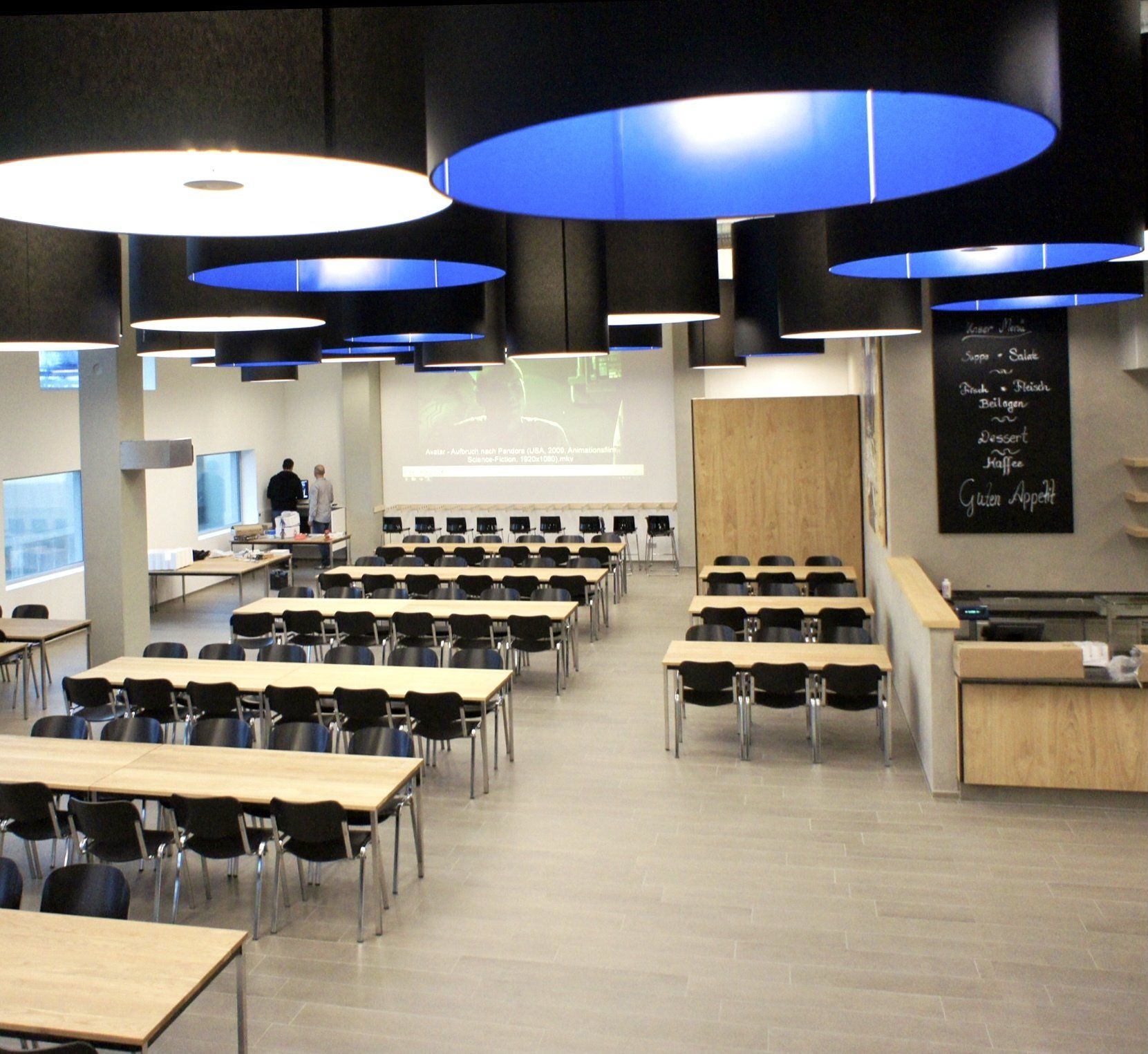 Ein großer Raum mit vielen Tischen und Stühlen