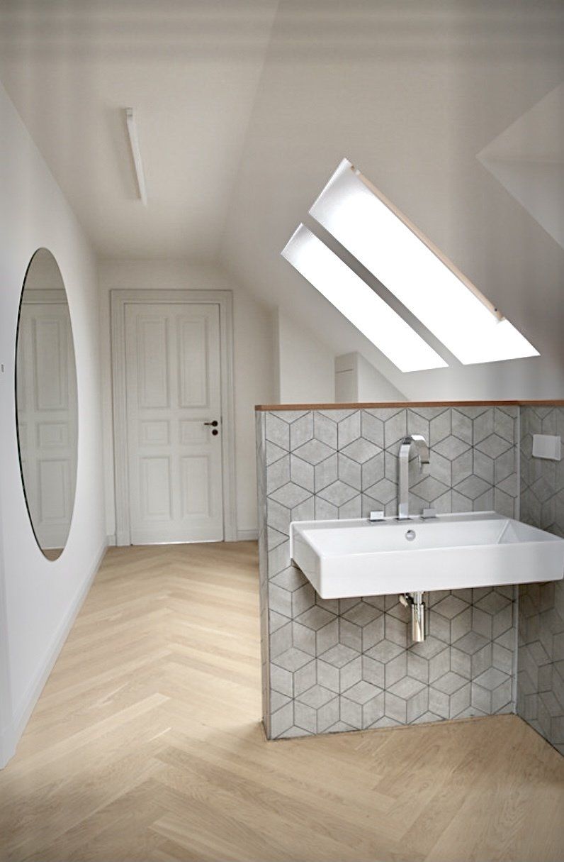 Ein Badezimmer mit Waschbecken, Spiegel und Oberlicht.