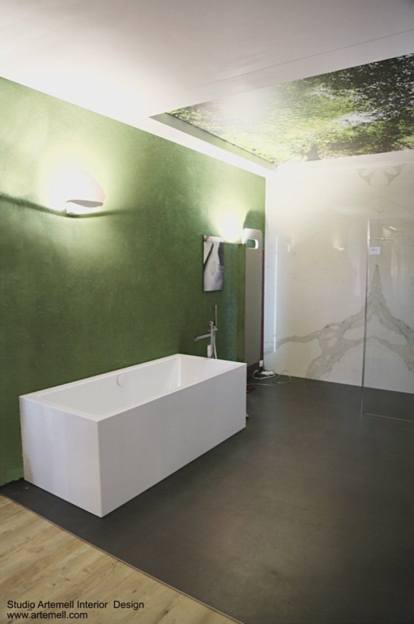 Ein Badezimmer mit Badewanne und grüner Wand.