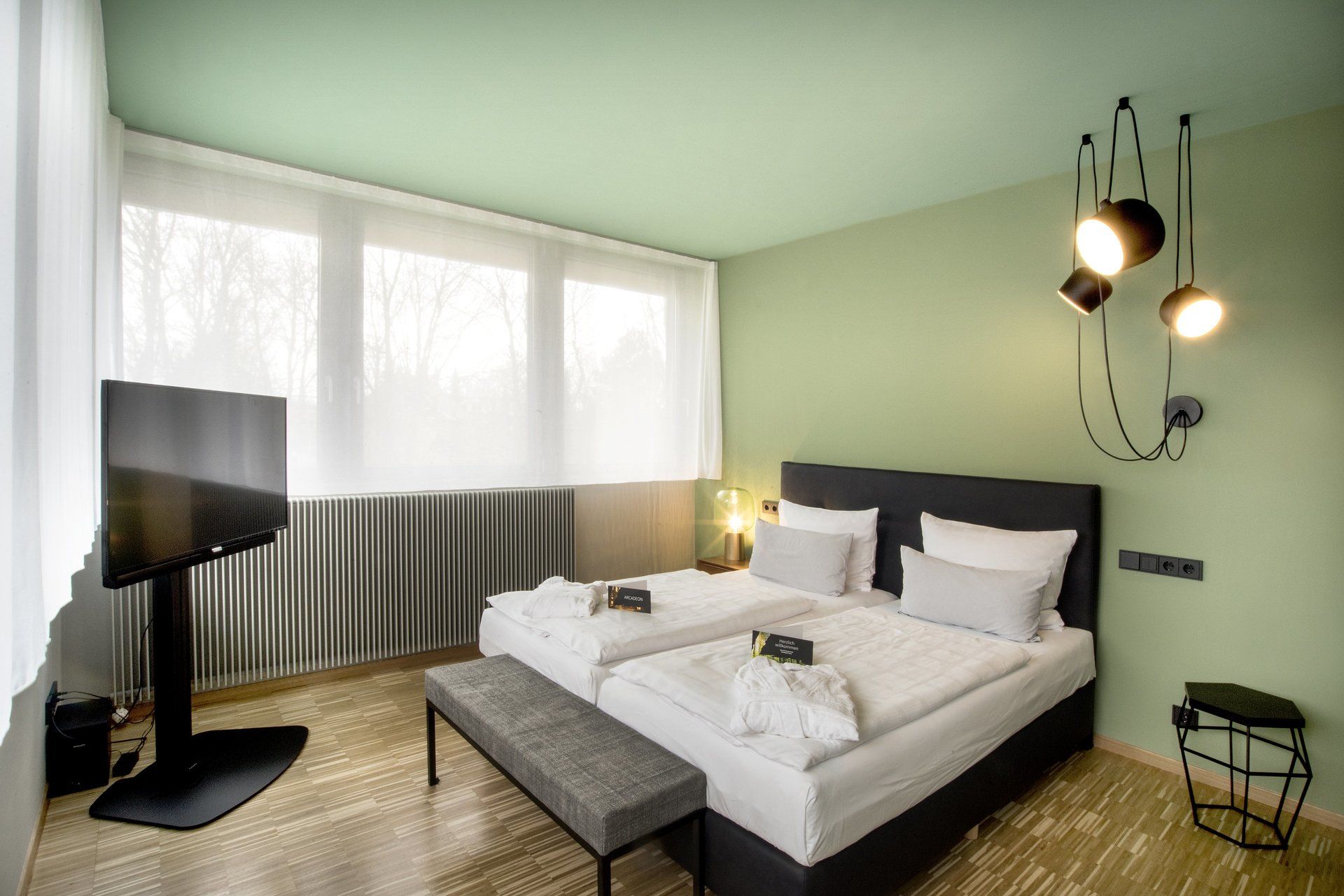 Ein Hotelzimmer mit zwei Betten und einem Flachbildfernseher.