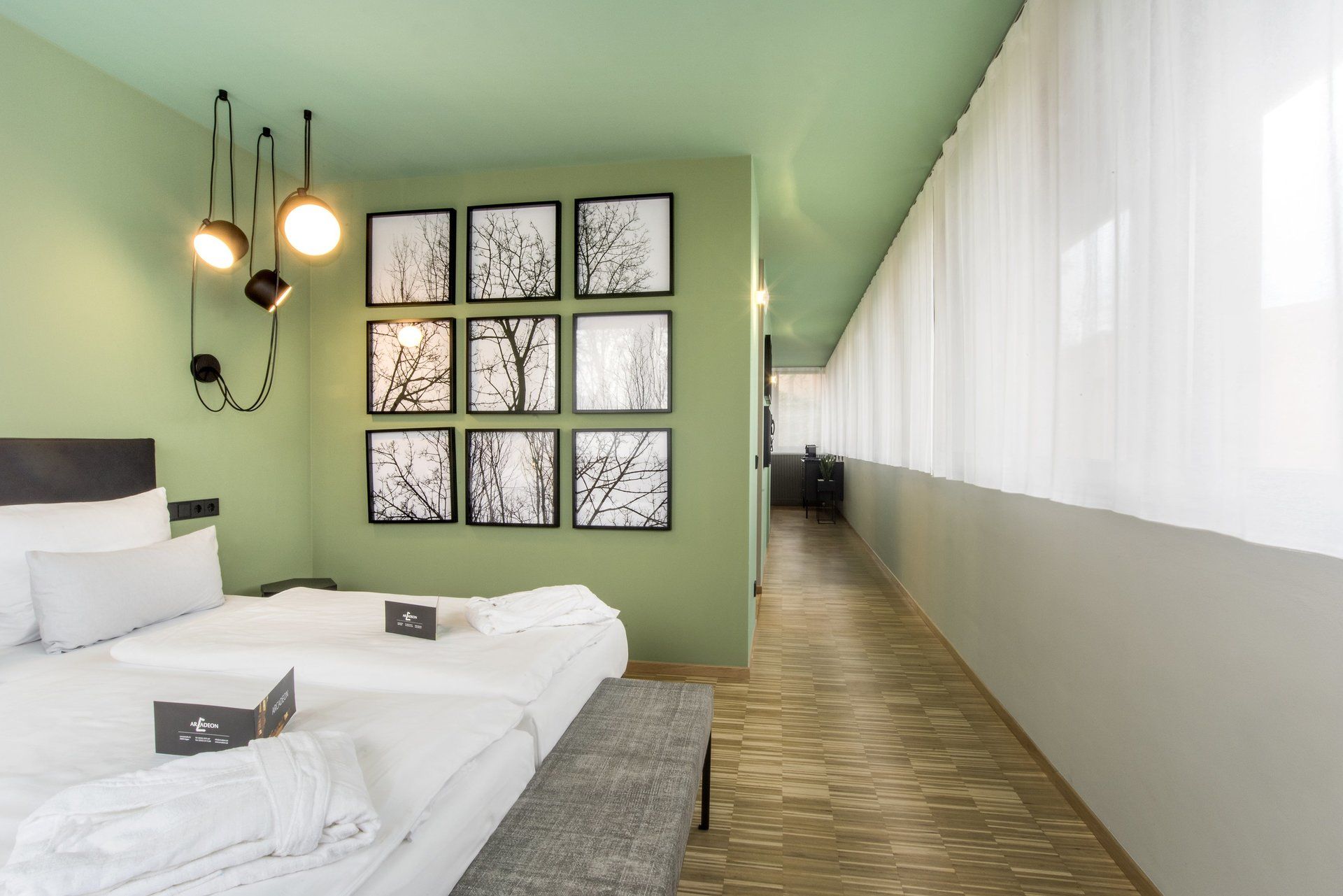 Ein Hotelzimmer mit Bett, Bank und Bildern an der Wand.